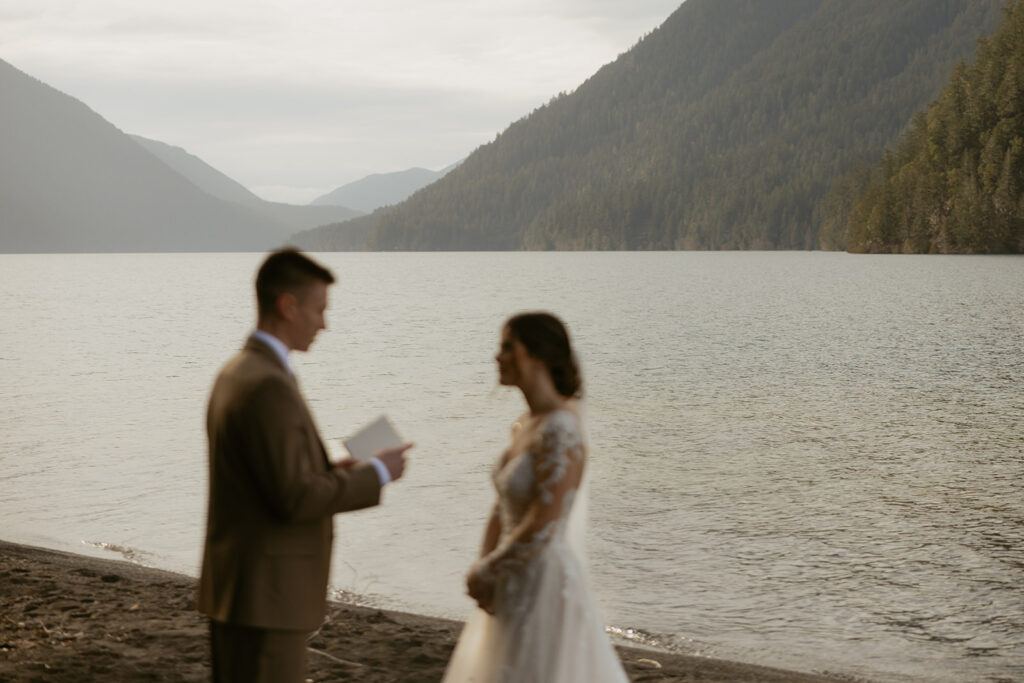 A bride and groom exchange vows next to Lake Crescent at their PNW elopement
