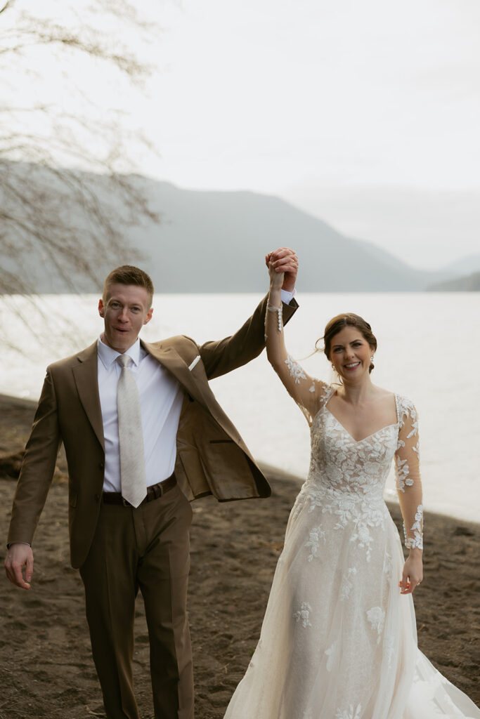 Newlyweds celebrate being officially married in a photo taken by an olympic national park elopement photographer at their Lake Crescent ceremony