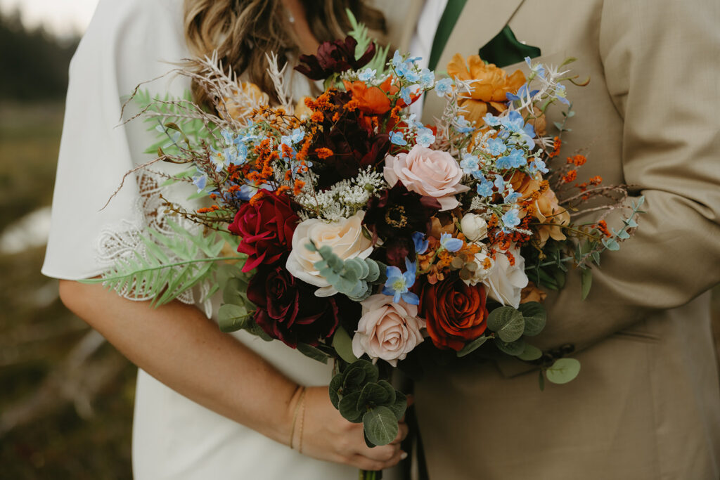 A bride's bouquet consisting of colorful roses and florals is shown in a mt baker wedding photo