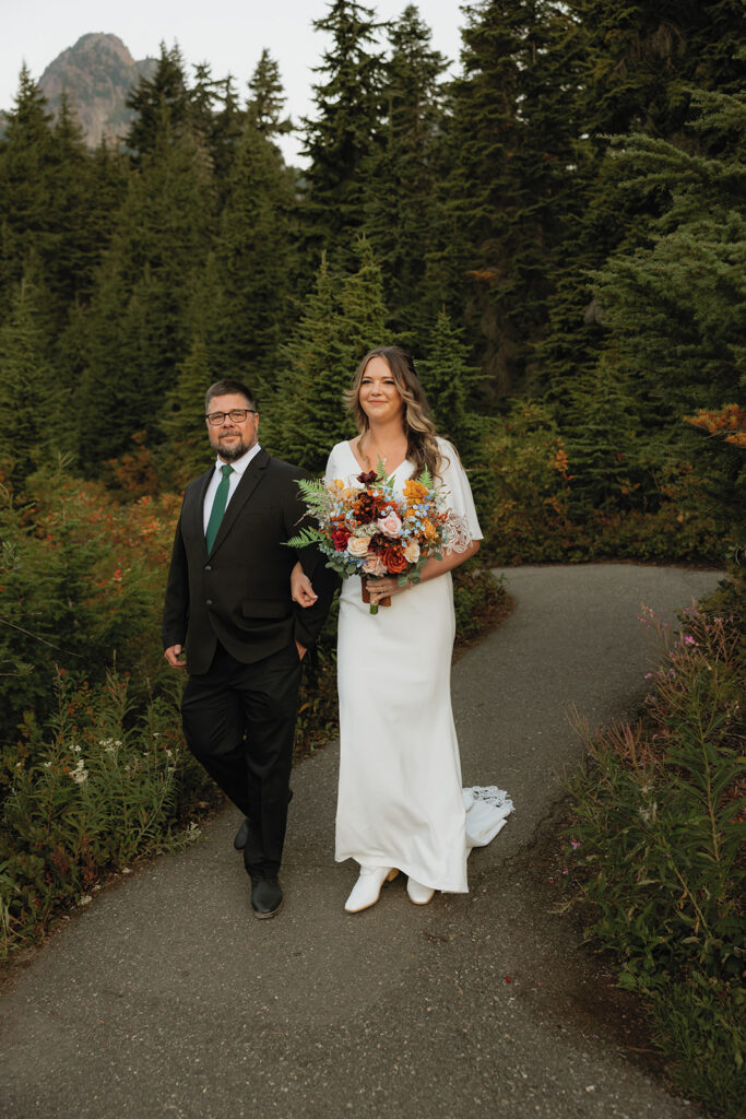 A bride is escorted down the aisle by her father at her Mt Baker wedding