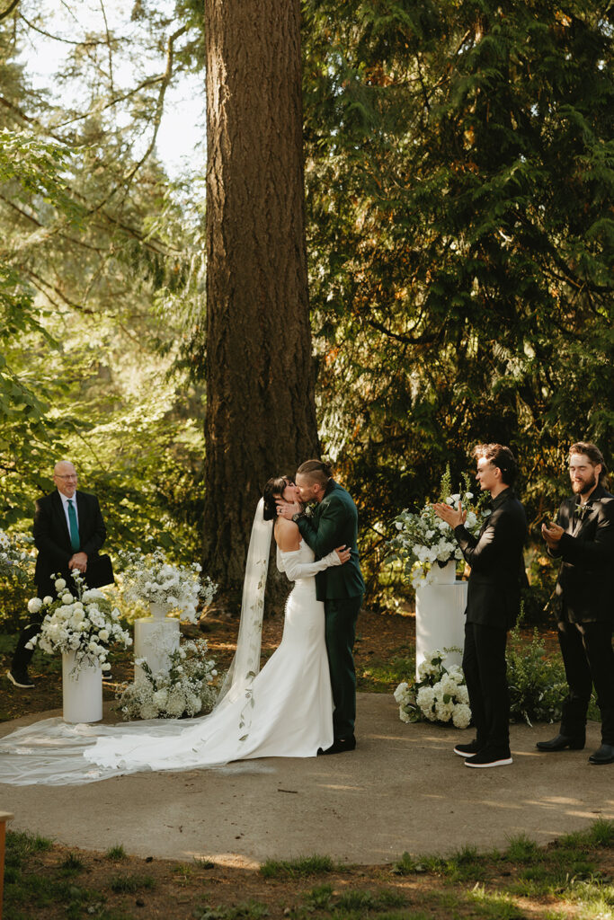 Newlyweds share a kiss at the altar at their Hoyt Arboretum wedding 