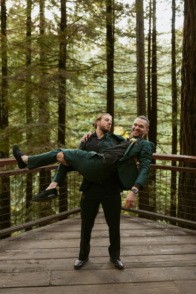 A groomsman lifts the groom for a fun photo taken at a Hoyt Arboretum Portland wedding