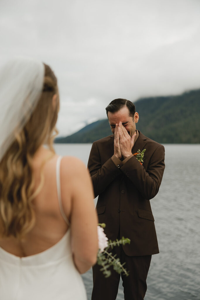 A groom's reaction is captured during a first look at an Olympic National Park wedding on Lake Crescent