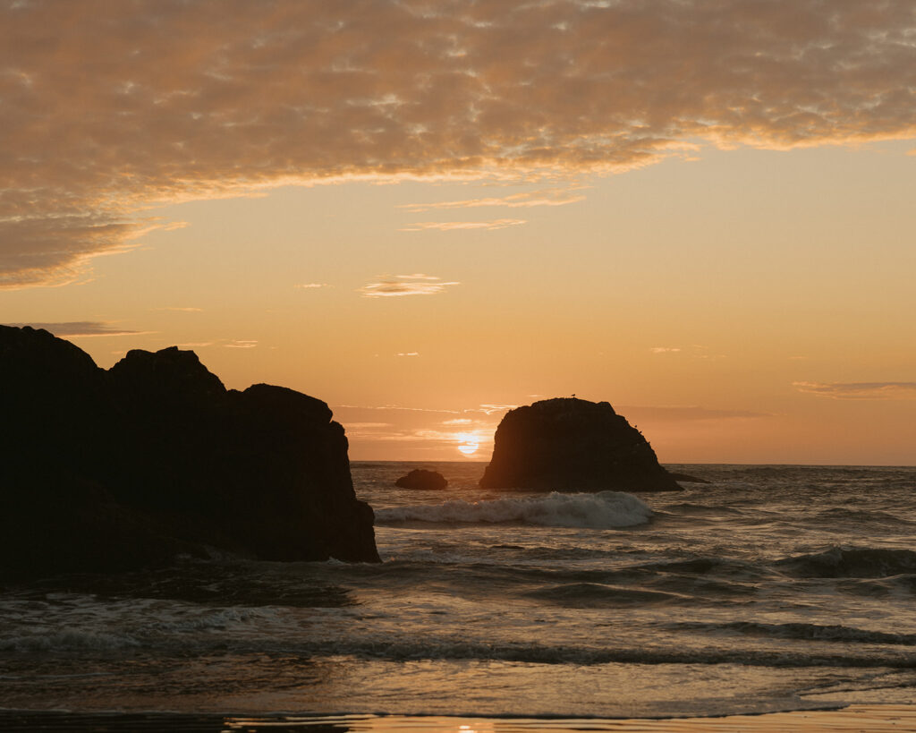 A sunset over the water is pictured at a Ruby Beach elopement