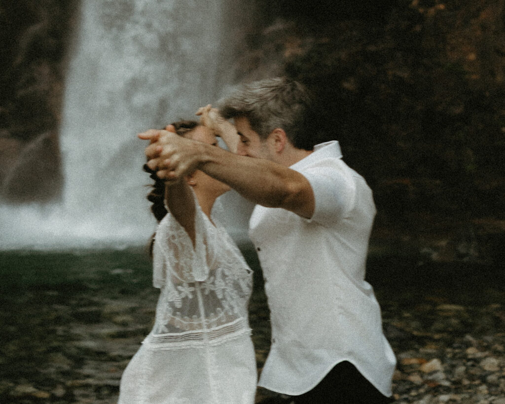 A couple wearing white are photographed during an engagement session at Franklin Falls WA