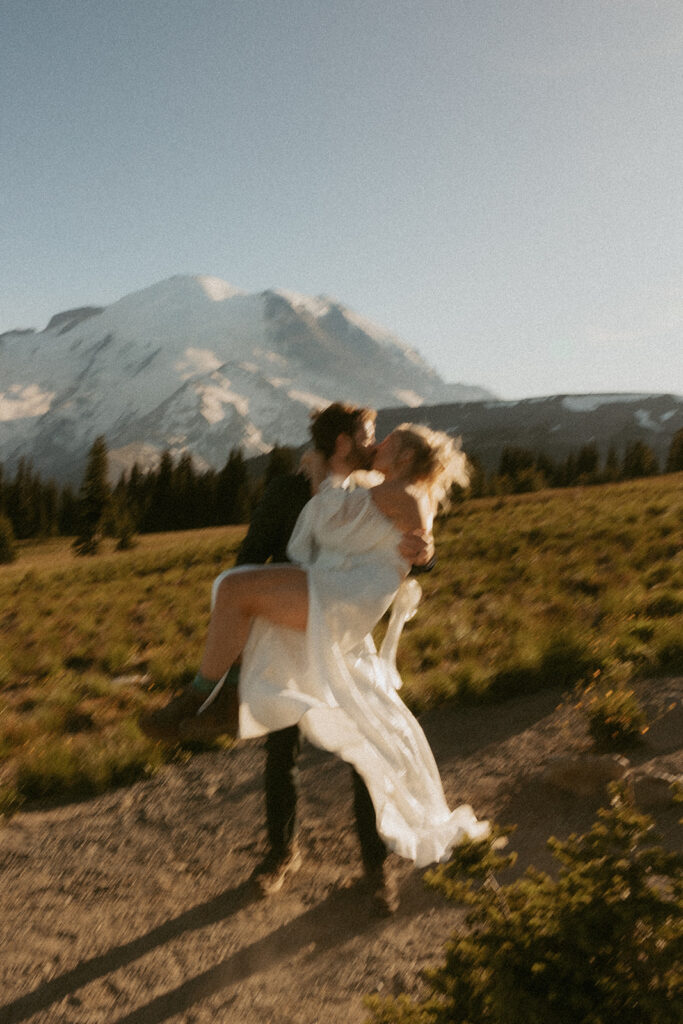 Newlyweds share a kiss in their wedding attire at their Mount Rainier elopement 