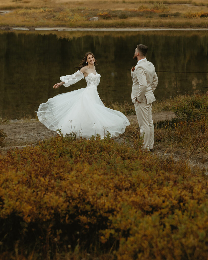 A bride twirls in her wedding gown next to Tipsoo Lake following her mount rainier national park elopement