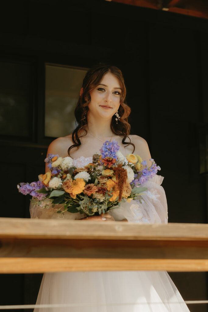 A bride to be is photographed in her wedding gown holding her bouquet before her mt rainier elopement