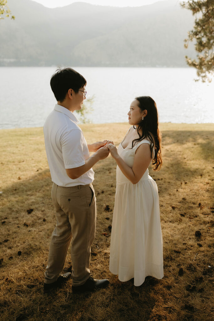 An engaged couple holds hands next to Lake Chelan in a photo taken by a photographer washington state