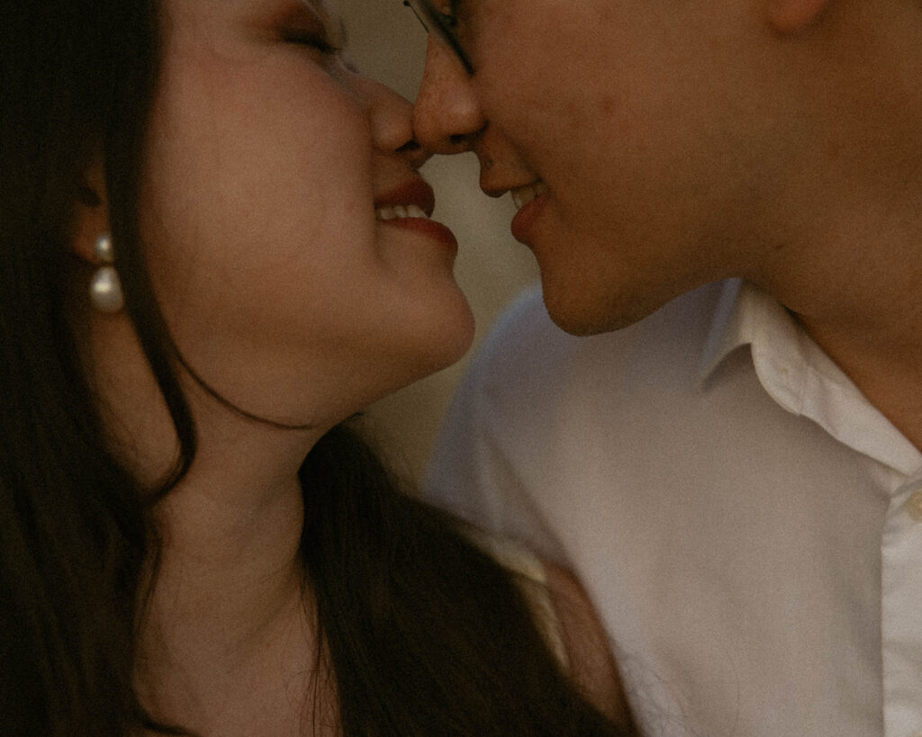 An engaged couple lean in for a kiss during an engagement session at Willow Point Park in Manson, WA