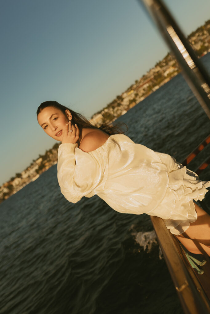 A woman wearing white leaning over the back of a boat on Lake Union