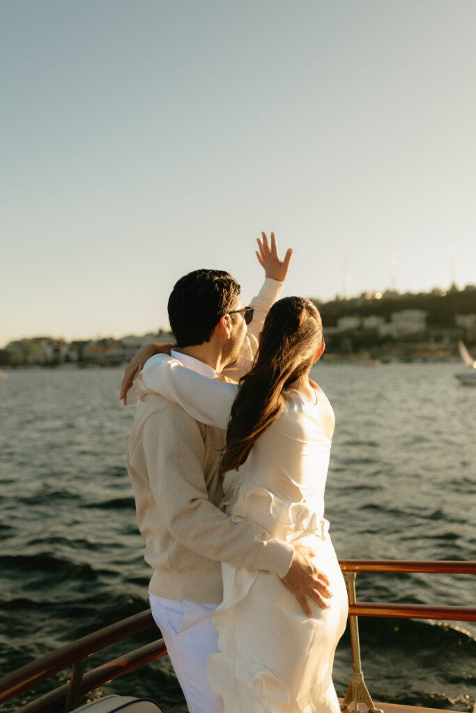 A couple waving to a passing boat