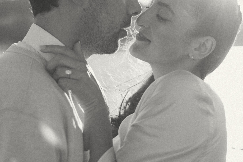 A black and white photo of a couple kissing during their engagement session