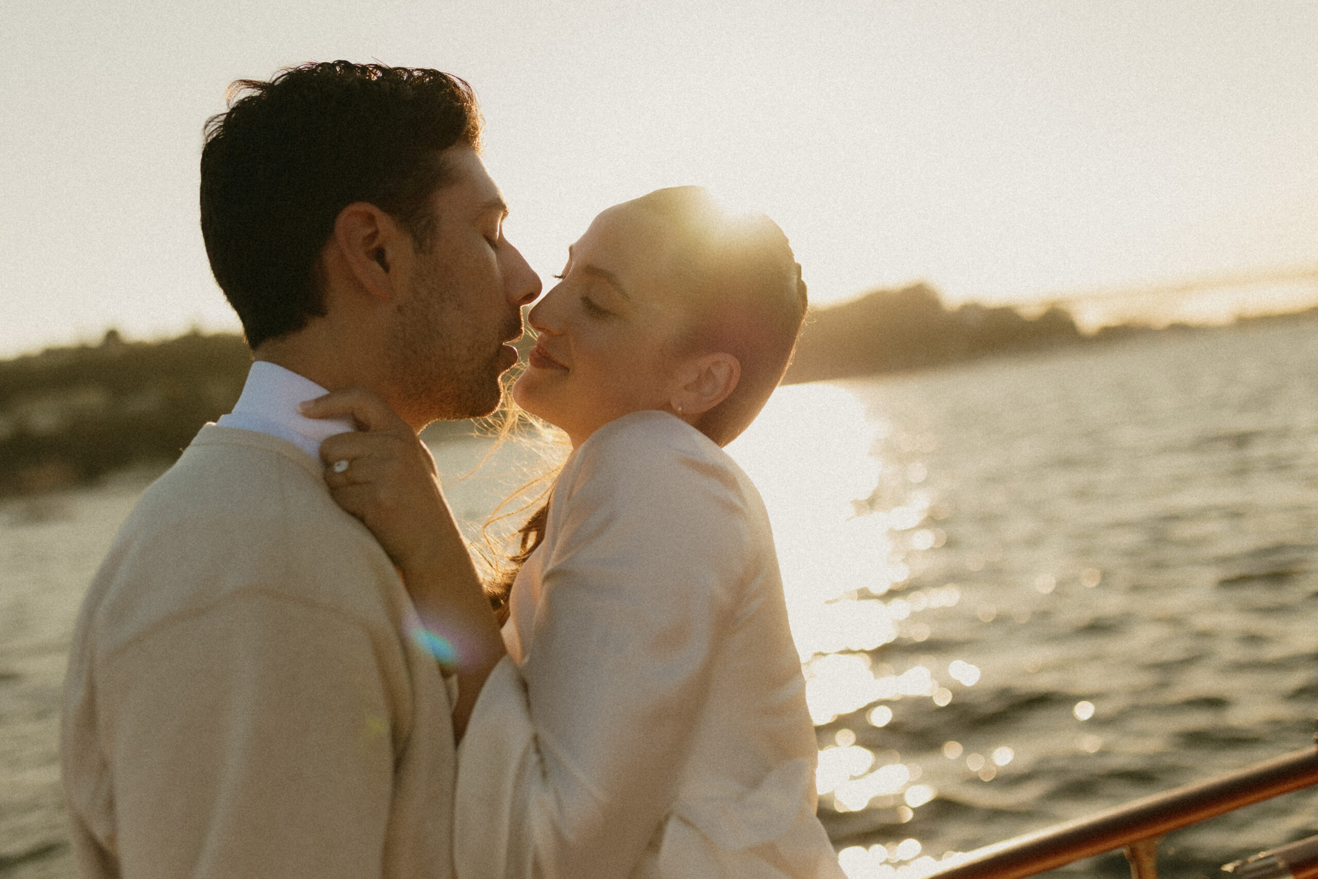A newly engaged couple smiling at each other during their sail boat engagement session in Seattle, WA