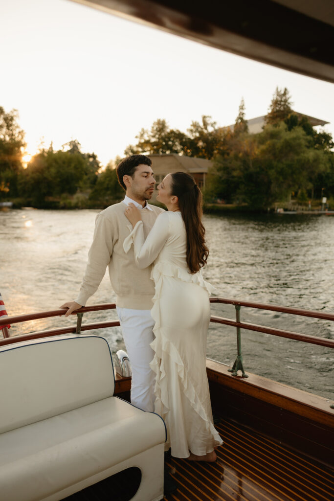 A couple smiling at each other in the back of a boat during their engagement session