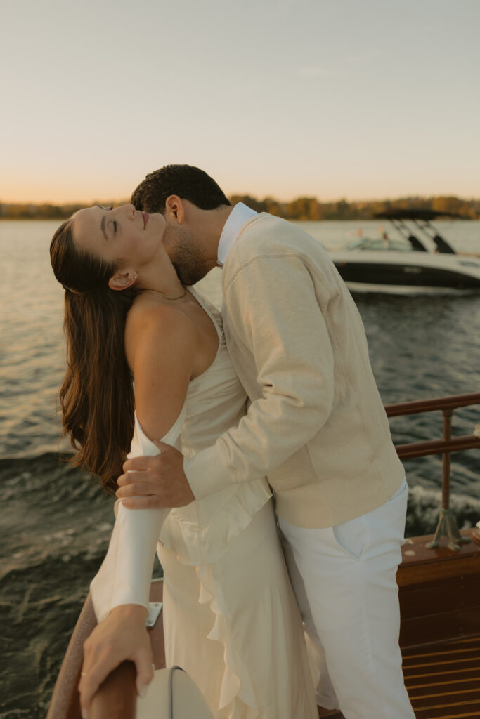 A man kissing a womans neck while on a boat