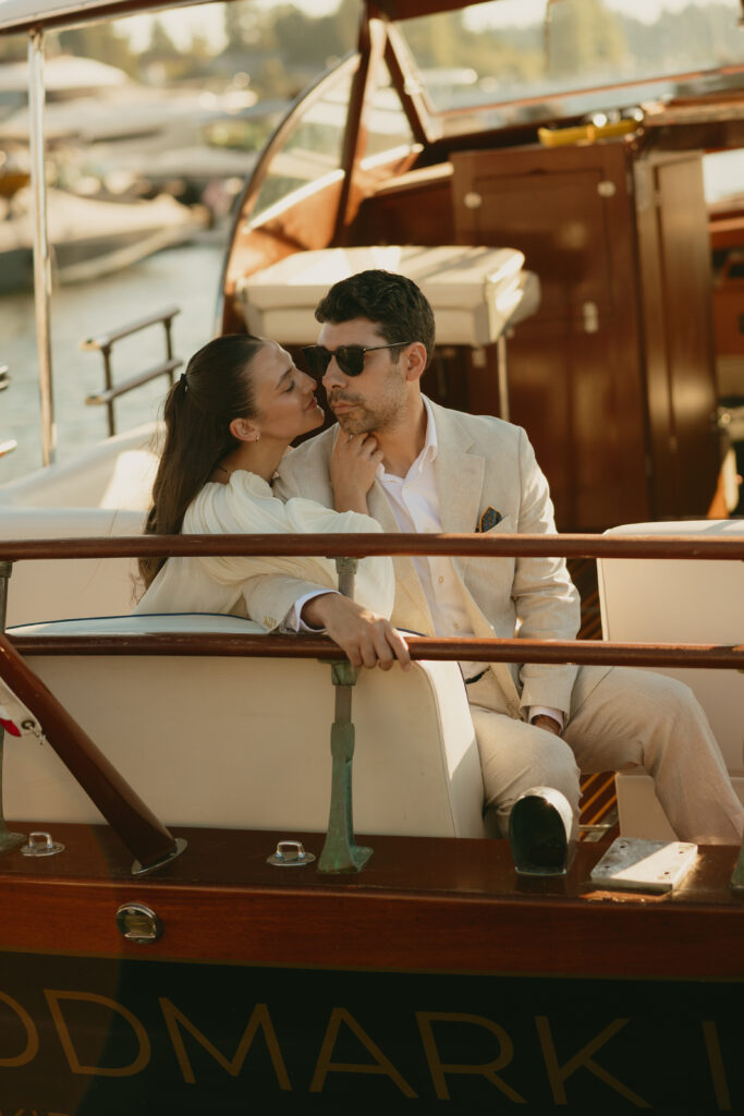 Couple sitting together in the back of a boat kissing