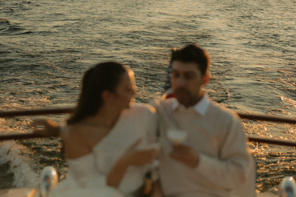 A man and woman drinking champagne together while on a boat