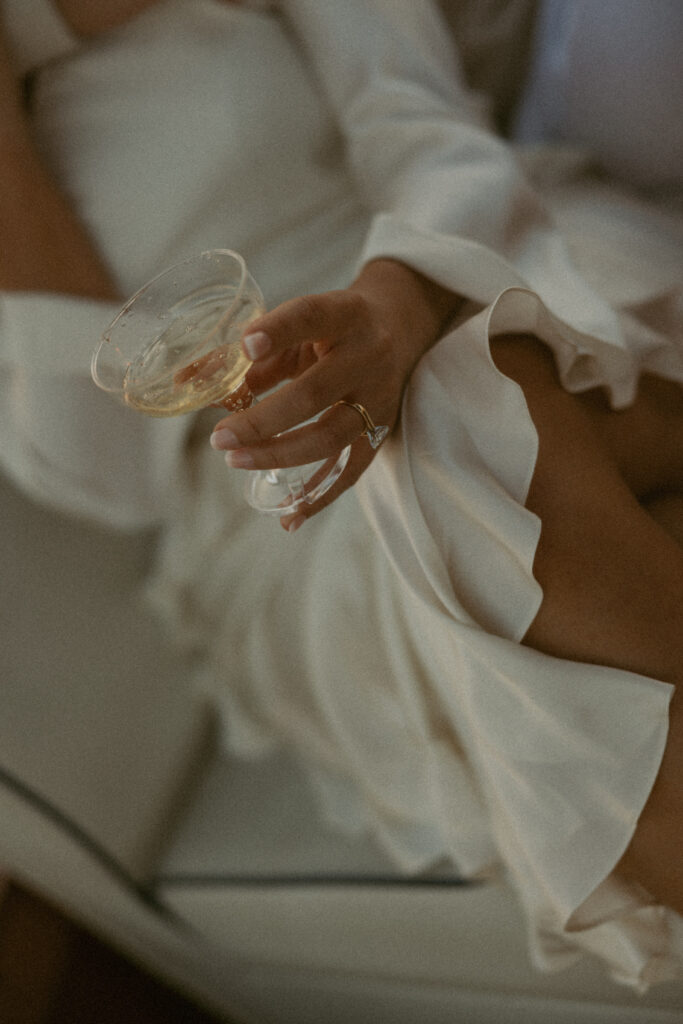 A woman wearing white holding a champagne glass